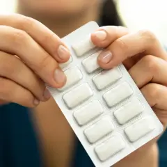 Dłonie trzymają blister z tabletkami na rzucenie palenia. To pierwszy krok do wolności od nałogu.