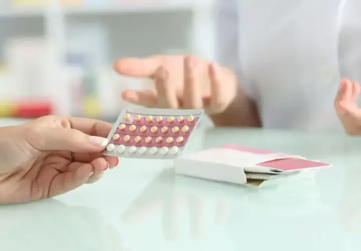 Dłoń trzyma blister tabletek antykoncepcyjnych. Farmaceuta wyjaśnia, bibloc na co.