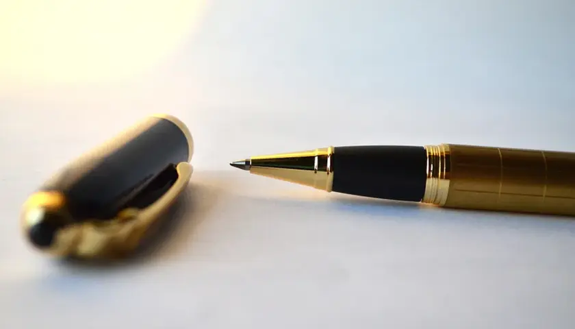 Eleganckie pióro z czarną skuwką i złotymi detalami, gotowe do złożenia ważnej kontrasygnaty.