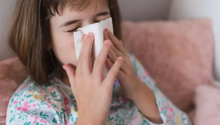 Dziewczynka z chusteczką przy nosie, być może potrzebuje antybiotyku na zatoki.