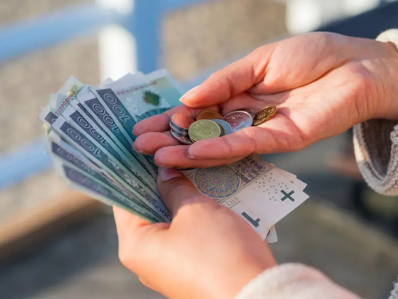 Dłonie liczą banknoty i monety. Czy to wystarczy na życie, gdy placa minimalna netto 2026 będzie obowiązywać?
