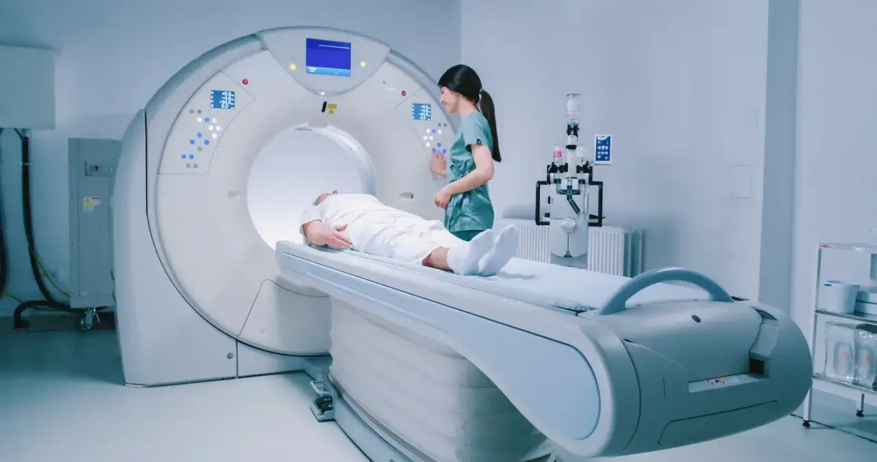 Pacjent leży na stole do rezonansu magnetycznego, a pielęgniarka przygotowuje badanie. To kluczowy moment dla diagnostyki, gdy rezonans głowy ujawni szczegóły.